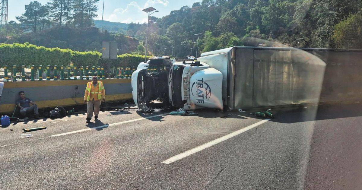 Tráiler brinca el muro de contención y vuelca en la pista